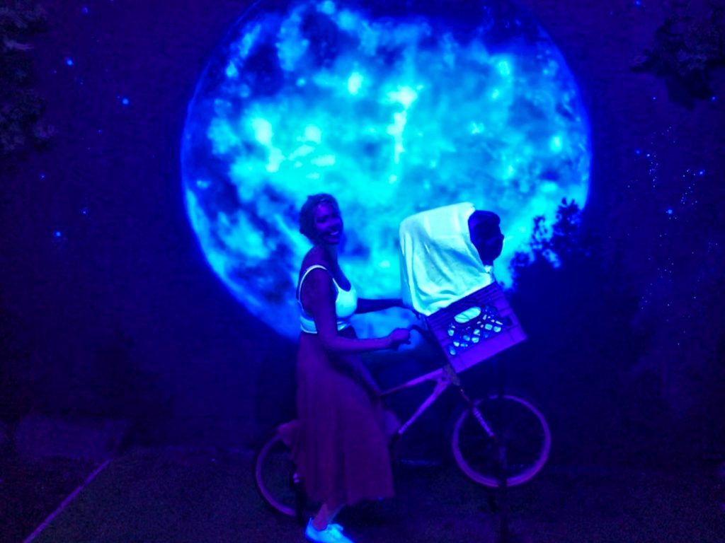 Nicola on ET's bike in front of a moon at Madame Tussauds Blackpool