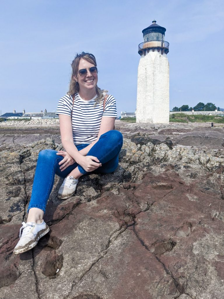 Nicola posing on the rocks in front of Southerness lighthouse