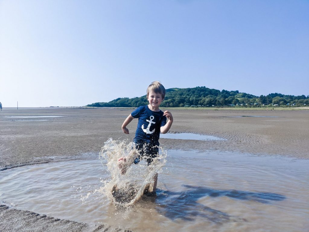 Dexter splashing a small pool of water at Sandyhills beach